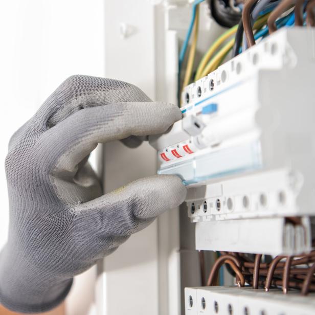 Electrician Testing Fuses In the Electric Box
