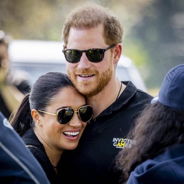 Prinz Harry und Meghan Markle umarmen sich lächelnd bei einer Veranstaltung der Invictus Games.