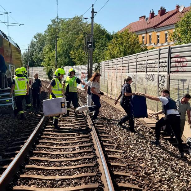 Menschen gehen über Bahngleise
