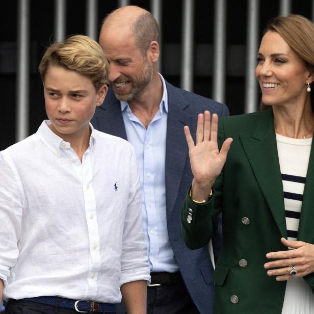 Prinz William, Prinzessin Kate und Prinz George bei einem öffentlichen Auftritt, bei dem Kate freundlich in die Menge winkt.