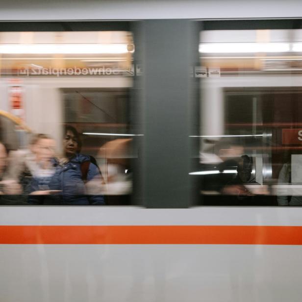 Eine Gruppe von Menschen, die in einem U-Bahn-Zug der Wiener Linien fahren