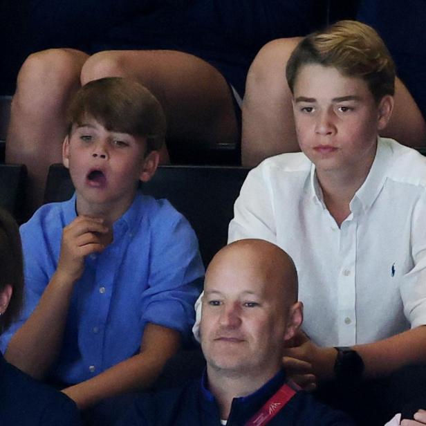 Prinz George und Prinz Louis sitzen auf einer Tribüne und schauen aufmerksam zu.