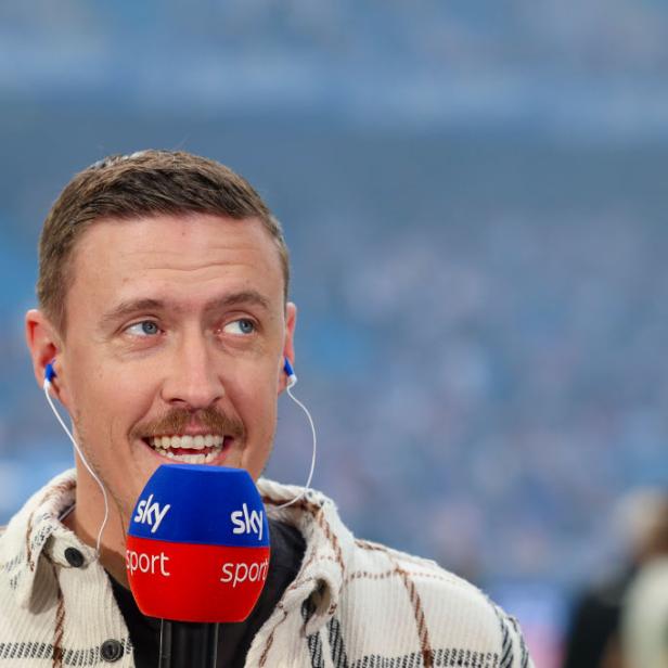 Max Kruse spricht bei Sky Sport mit einem Mikrofon und blickt lächelnd zur Seite.