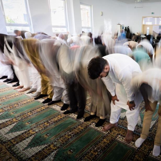 Gläubige beten in einer Moschee im Gebetssaal, während sie sich gemeinsam verbeugen.