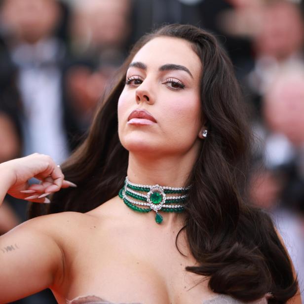 Georgina Rodríguez trägt eine auffällige Smaragd-Halskette mit Diamanten vor einem unscharfen Hintergrund.