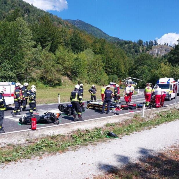 Rettungskräfte versorgen nach einem Motorradcrash zwei verunglückte Bikes auf einer Landstraße.
