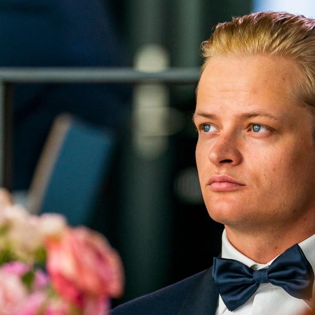 Marius Borg Høiby mit blondem Haar und Fliege blickt aufmerksam zur Seite.