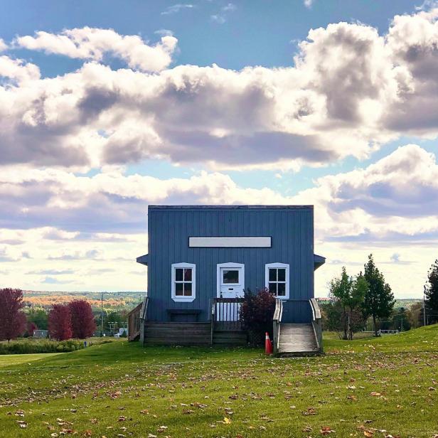 Blaues Tiny House auf einer Wiese