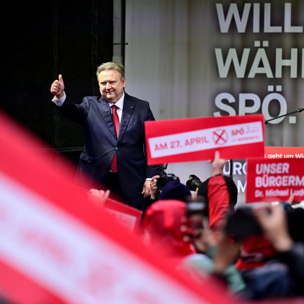 Michael Ludwig zeigt vor einer SPÖ-Wahlkampfveranstaltung mit Unterstützern und Schildern den Daumen nach oben.