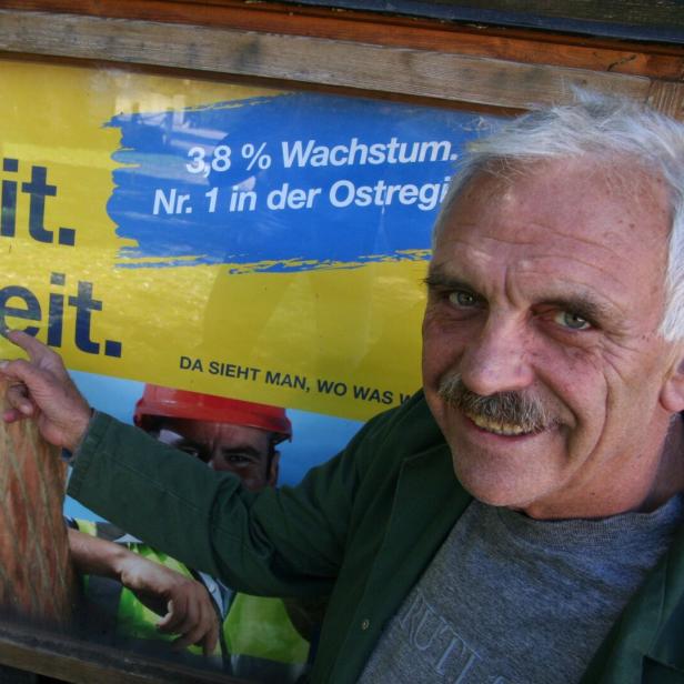Ein Mann vor einem Plakat