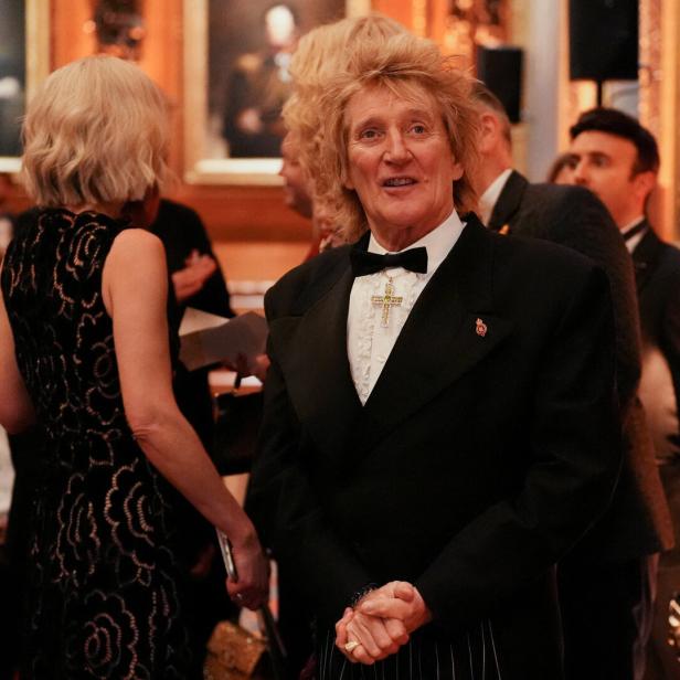 Rod Stewart trägt einen schwarzen Smoking mit Fliege und ein auffälliges Kreuz-Amulett bei einer formellen Veranstaltung.