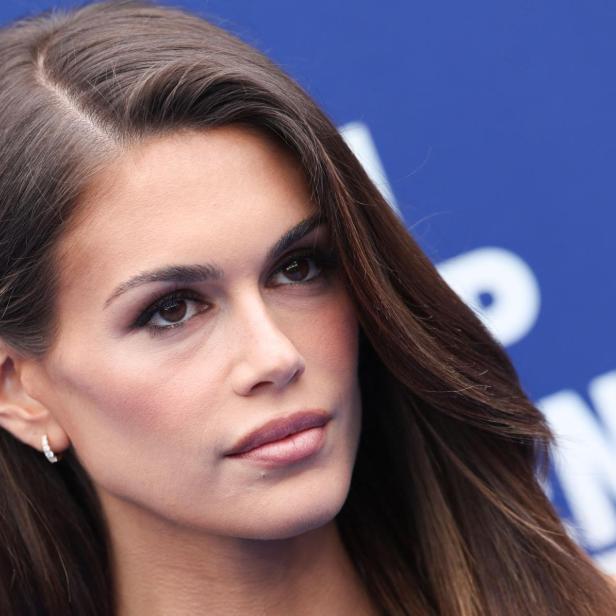 Nahaufnahme von Kaia Gerber vor einem blauen Hintergrund.
