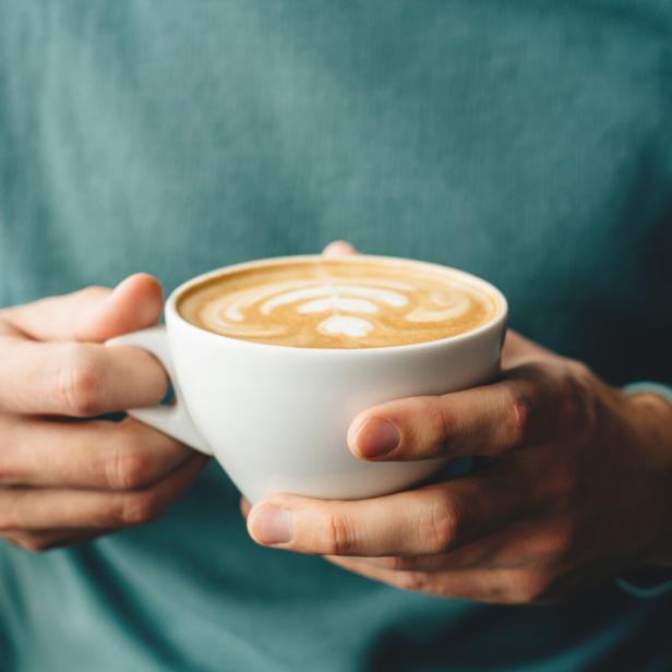 The cup of cappuccino in men's hands