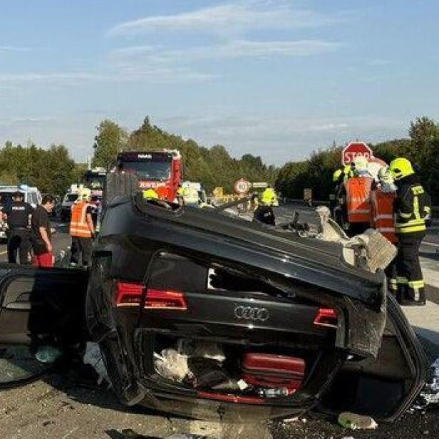 Umgestürztes Auto auf der Autobahn, Rettungskräfte im Einsatz.