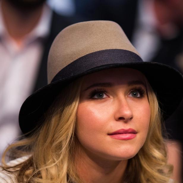 Hayden Panettiere mit einem beigefarbenen Hut mit schwarzem Band blickt aufmerksam nach oben.