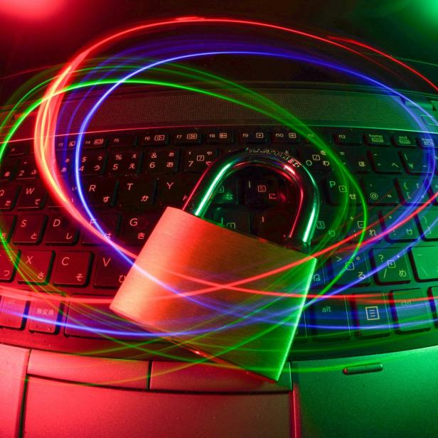 Laptopschloss auf beleuchteter Tastatur mit Lichtspuren.