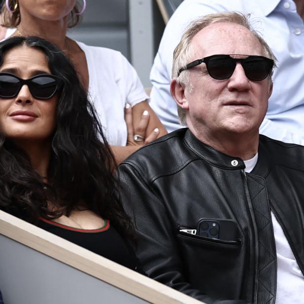 Salma Hayek und François-Henri Pinault sitzen nebeneinander auf der Tribüne und tragen beide eine Sonnenbrille.