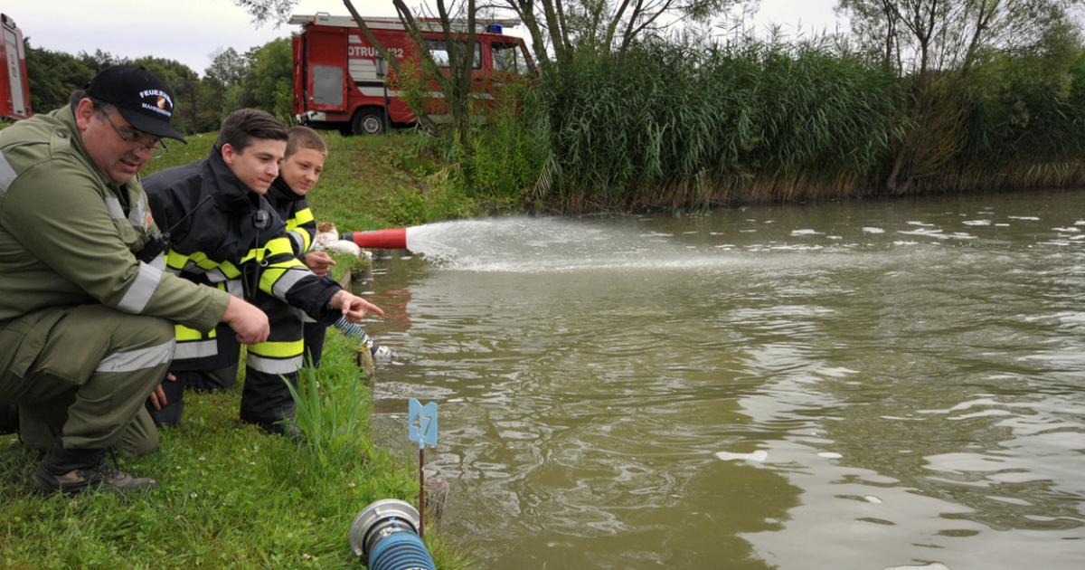 Feuerwehr kämpft bei Teich gegen Fischsterben