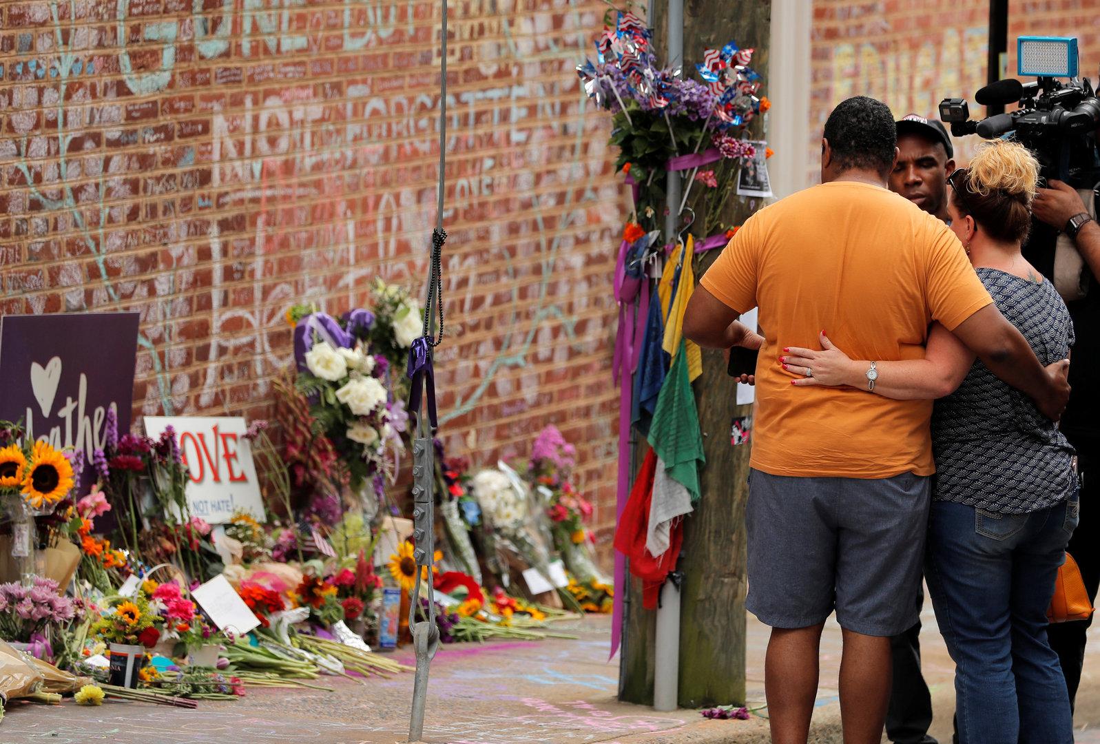 People embace at a memorial near the site where Heather Heyer was killed during the 2017 Charlottesville "Unite the Right" protests in Charlottesville