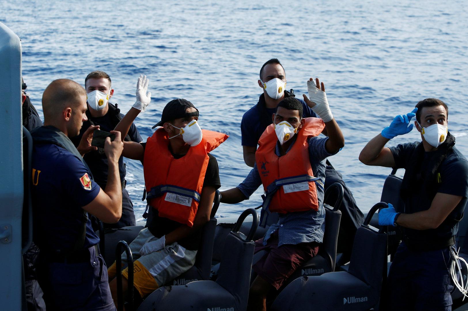 Two Tunisian migrants being medically evacuated to Malta by the Armed Forces of Malta wave to colleagues and crew on the German NGO Sea-Eye migrant rescue ship 'Alan Kurdi' in international waters off Malta in the central Mediterranean Sea