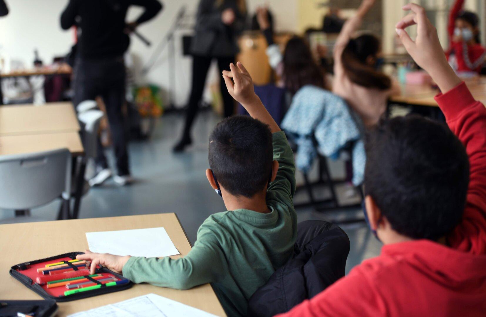 Schüler melden sich im Klassenzimmer während des Unterrichts.