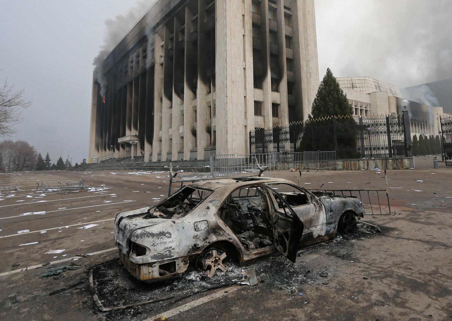 A burned car is seen in front of the mayor's office building which was torched during protests in Almaty