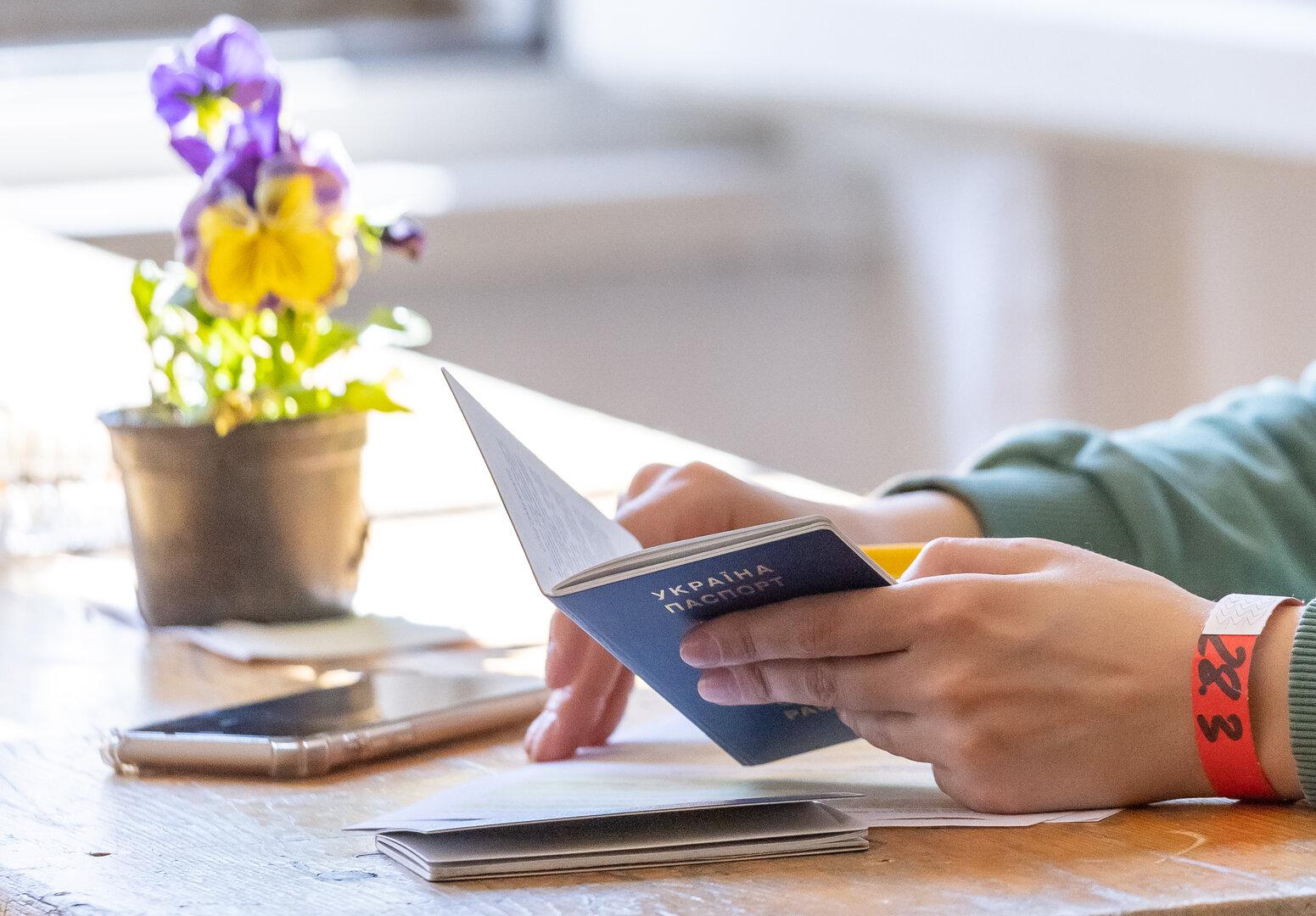 Eine Person hält einen ukrainischen Reisepass in der Hand.