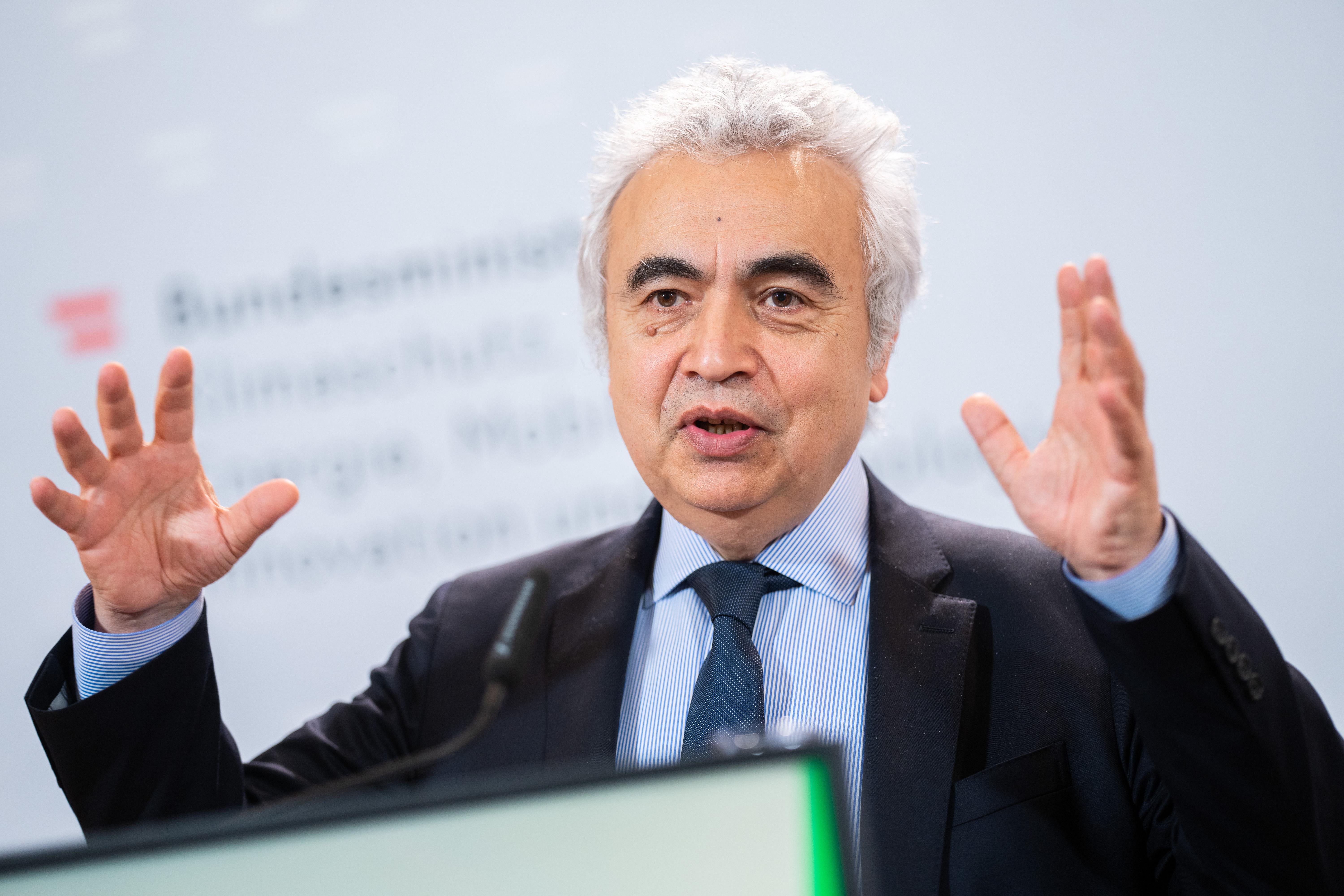 Ein Mann mit grauem Haar gestikuliert vor einem Mikrofon.