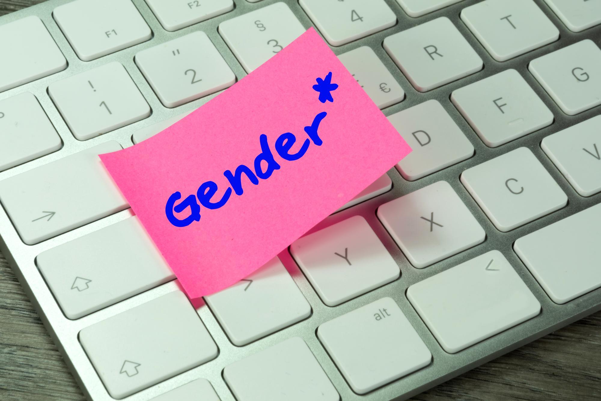 Ein pinkfarbener Notizzettel mit dem Wort „Gender“ liegt auf einer Computertastatur.