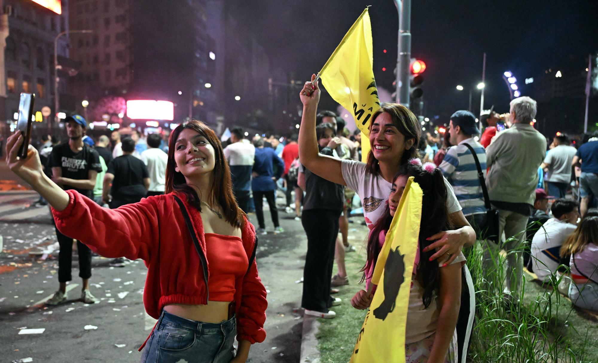 Die 19-jährige Fernanda (19, l.) feiert mit ihrer Freundin den Wahlsieg des neuen argentinischen Präsidenten Javier Milei auf der Avinguda de Mayo in Buenos Aires.