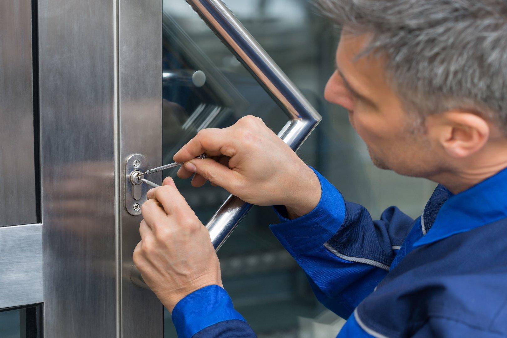Male Lockpicker Fixing Door Handle At Home Arbeiter des Schlüsseldienstes beim Öffnen der Haustüre.