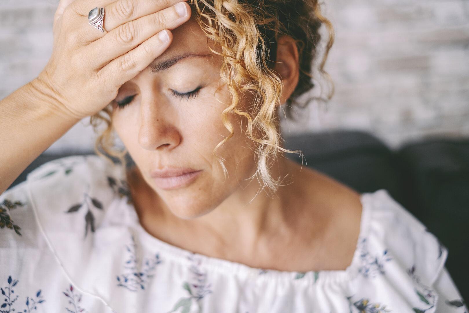 Eine Frau greift sich auf den Kopf.