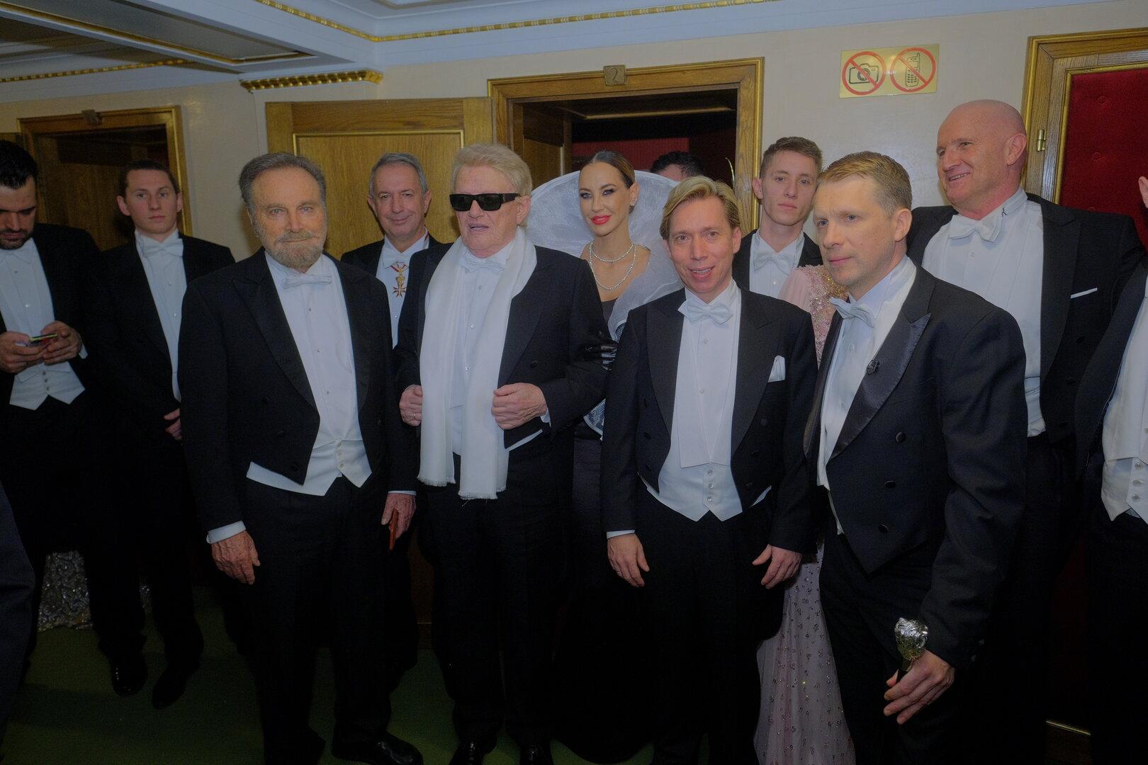 Eine Gruppe von elegant gekleideten Menschen posiert für ein Foto.