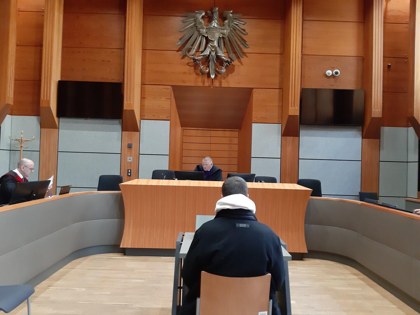 Ein Gerichtssaal mit Richtern und einem Angeklagten.
