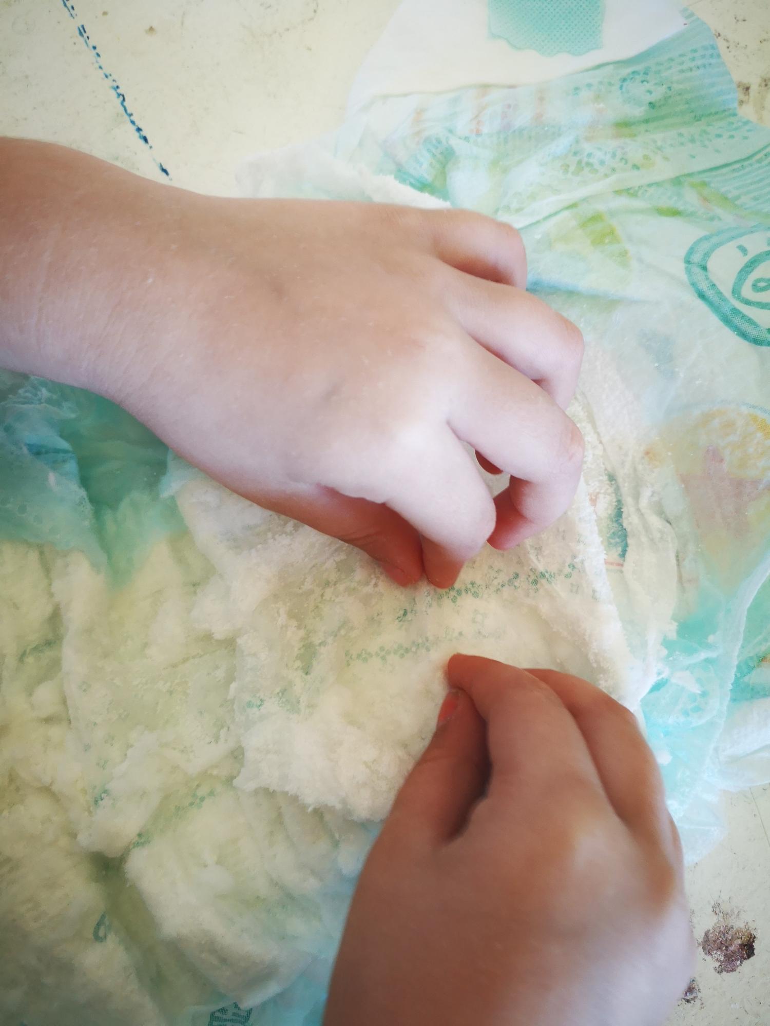 Ein Kind entnimmt Pulver aus einer Windel.