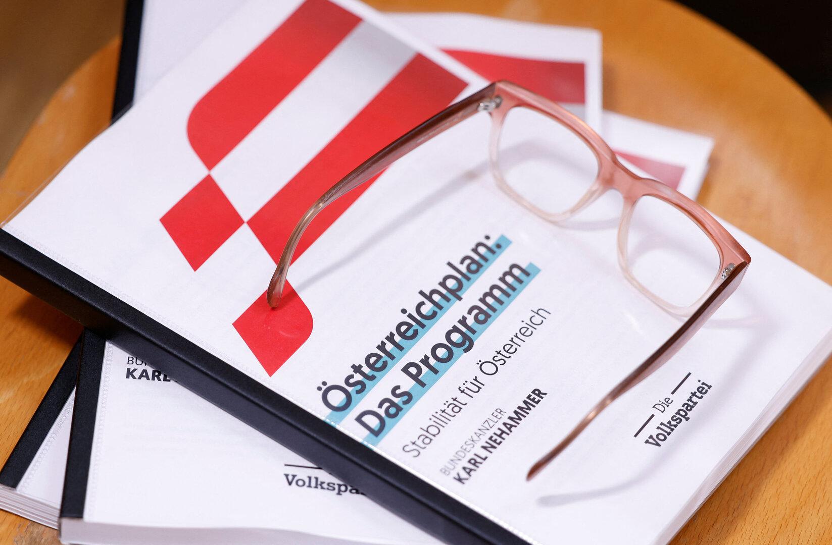 Eine Broschüre des „Österreichplan: Das Programm“ mit einer Brille darauf.