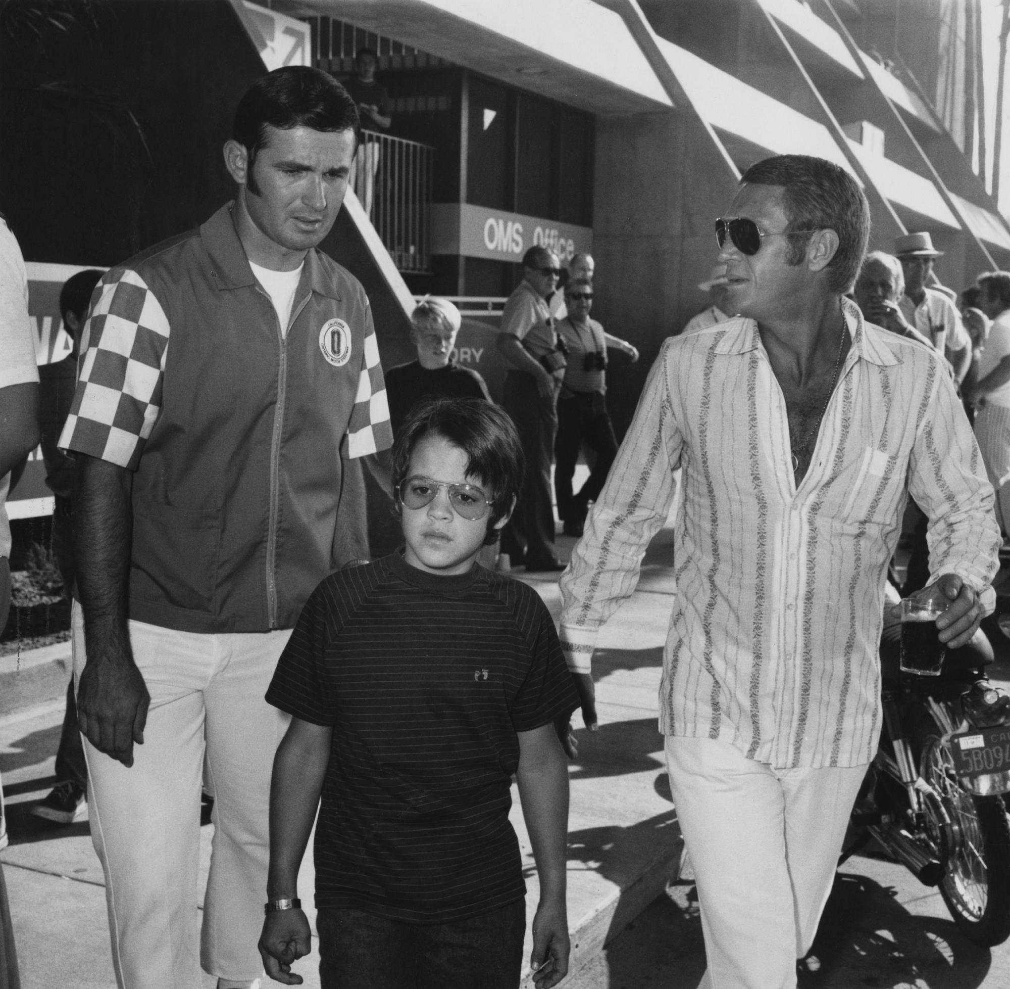 Der amerikanische Schauspieler Steve McQueen (1930 - 1980) mit seinem Sohn Chad beim California-500-Indycar-Rennen in Ontario, Kalifornien, im September 1971.