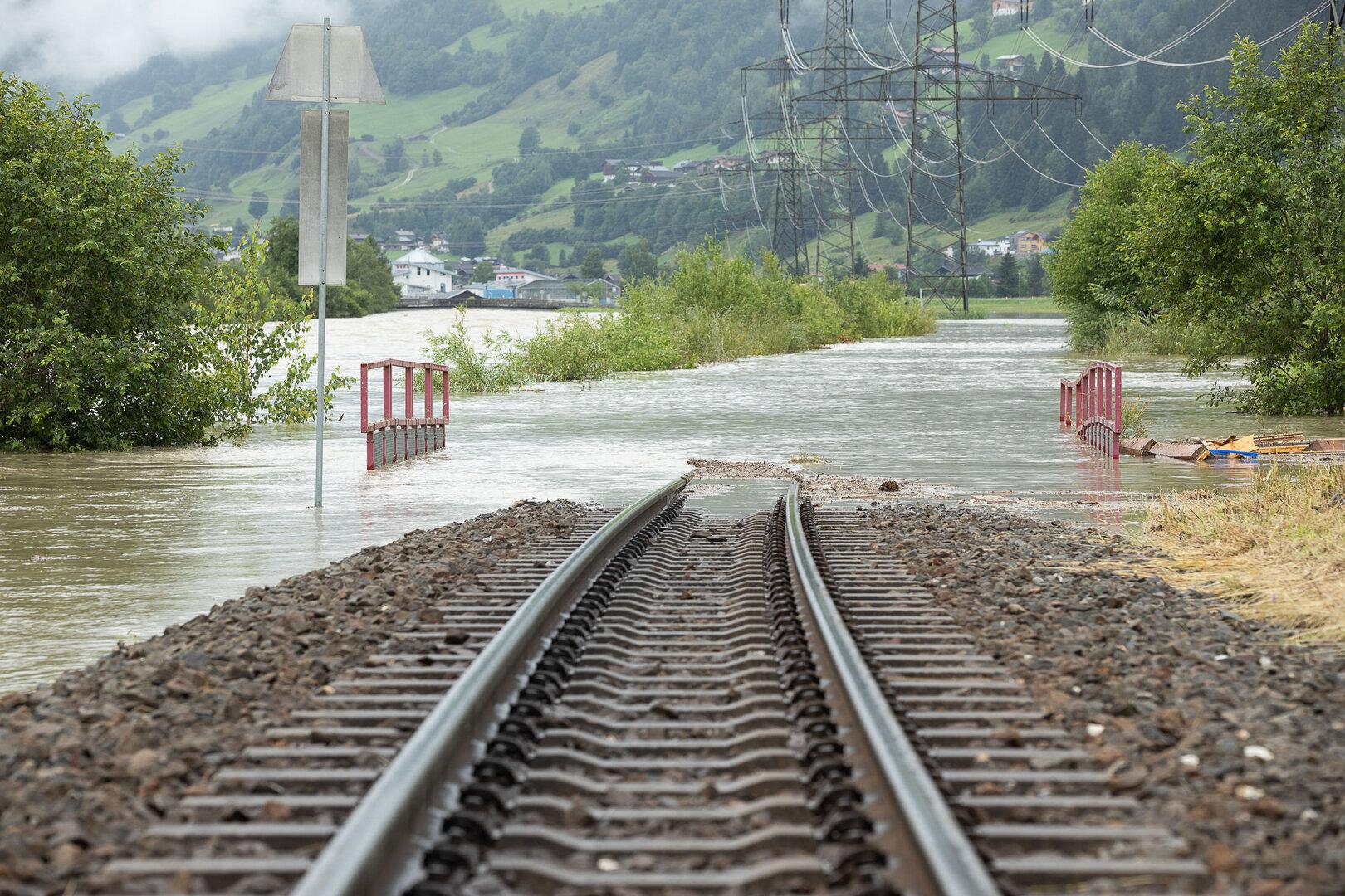 Hochwasser hat eine Bahnstrecke und die umliegende Landschaft überschwemmt.