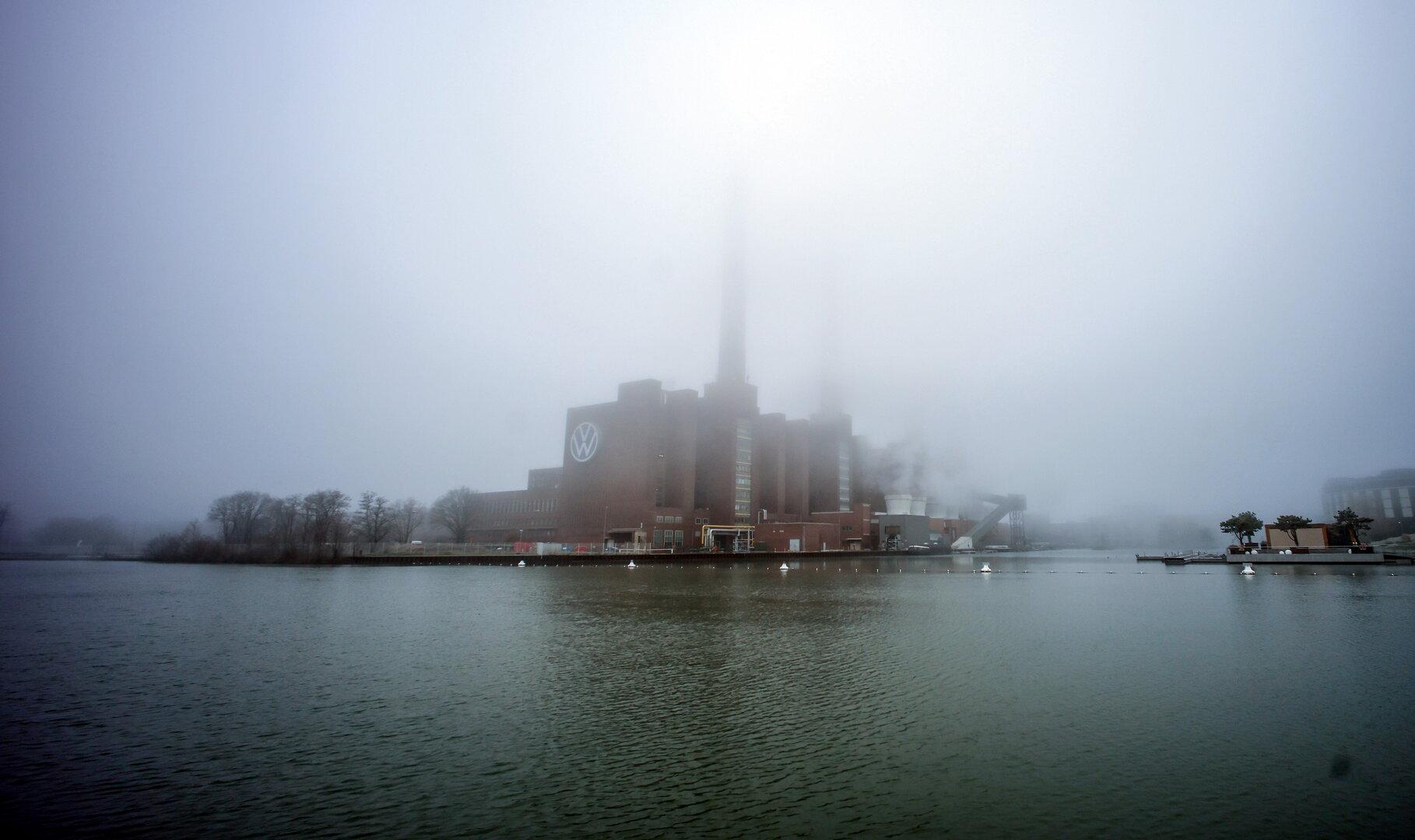 Das Volkswagenwerk Wolfsburg liegt im Nebel am Ufer des Mittellandkanals.