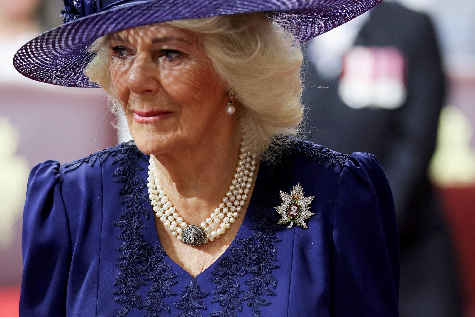 Königin Camilla trägt einen Hut und eine Perlenkette.