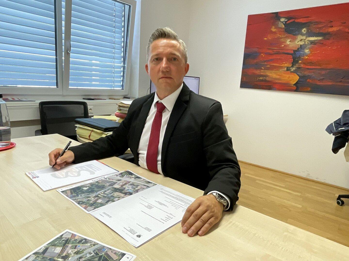 Anwalt Gerhard Ederer sitzt an seinem Schreibtisch und arbeitet an Dokumenten.