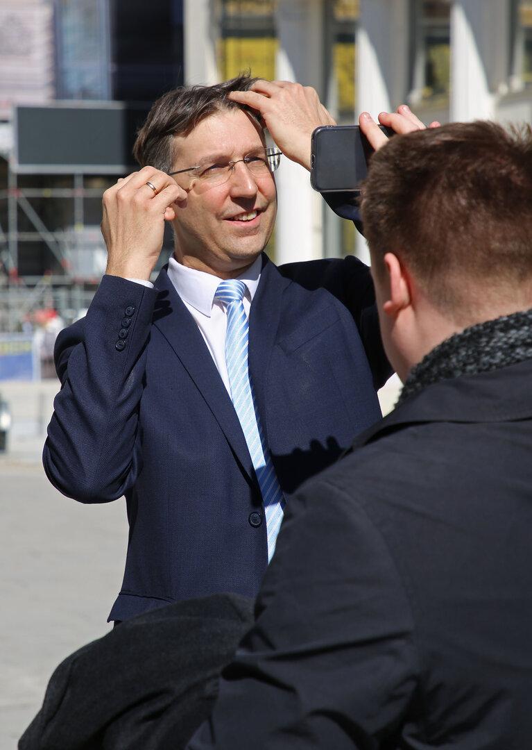 Ein Mann im Anzug wird auf dem Neuen Markt fotografiert.