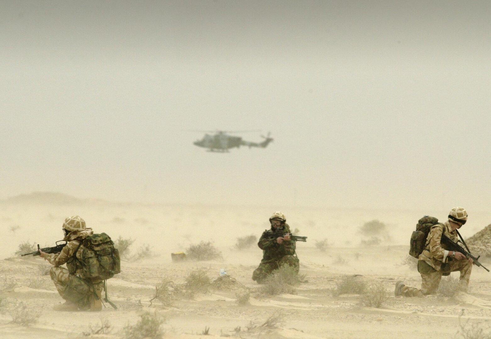 FILE PHOTO: Soldiers attached to Britain's 3 Army Air Corps patrol the desert around the oil fields of north Ramaila in Iraq