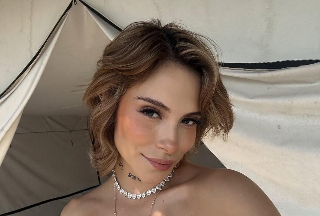 28-jährige Frau mit kurzen blonden Haaren lächelt in die Kamera für ein Selfie