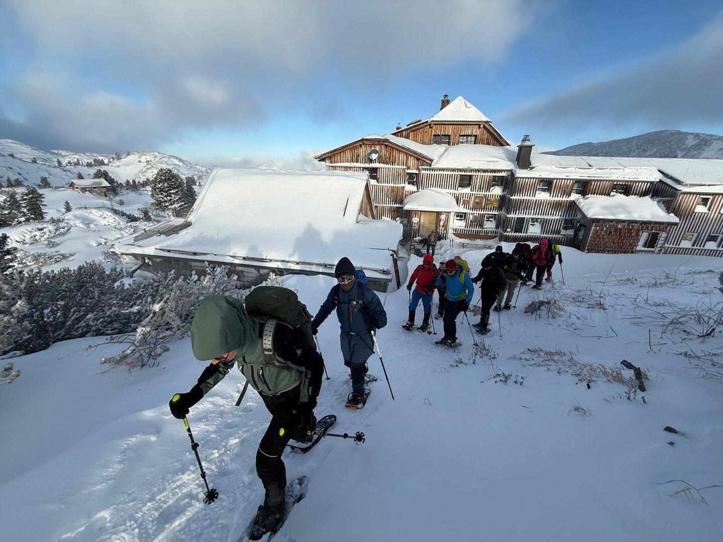 Hütte in den Bergen, Schneeschuhwanderer im vordergrund