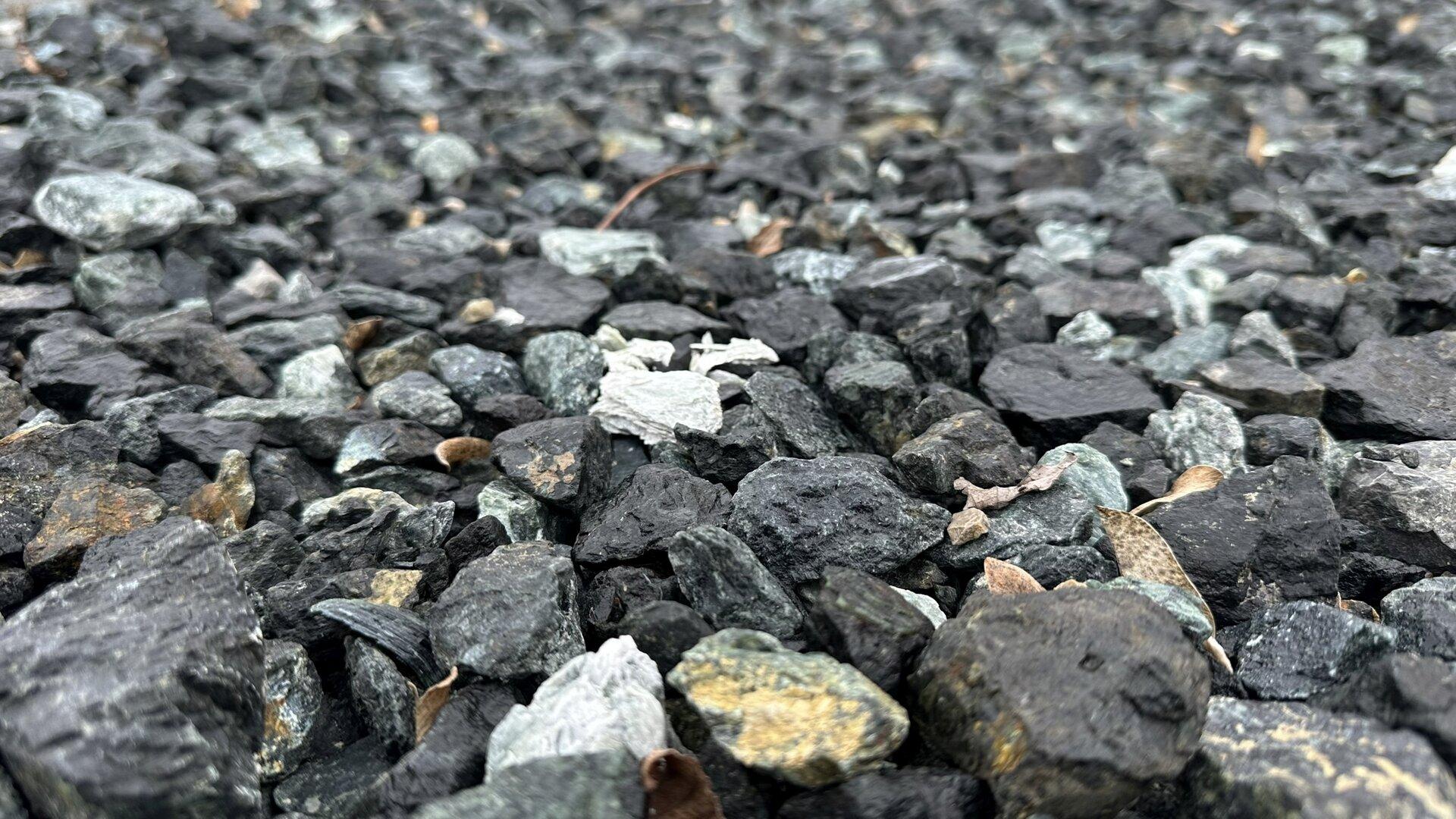 Viele kleine, unterschiedlich gefärbte Steine liegen dicht nebeneinander auf dem Boden.
