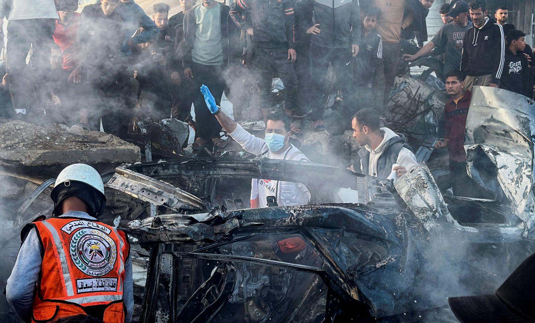 Emergency services work at the site of what medics said was an Israeli airstrike on a car near the entrance to Zawayda town