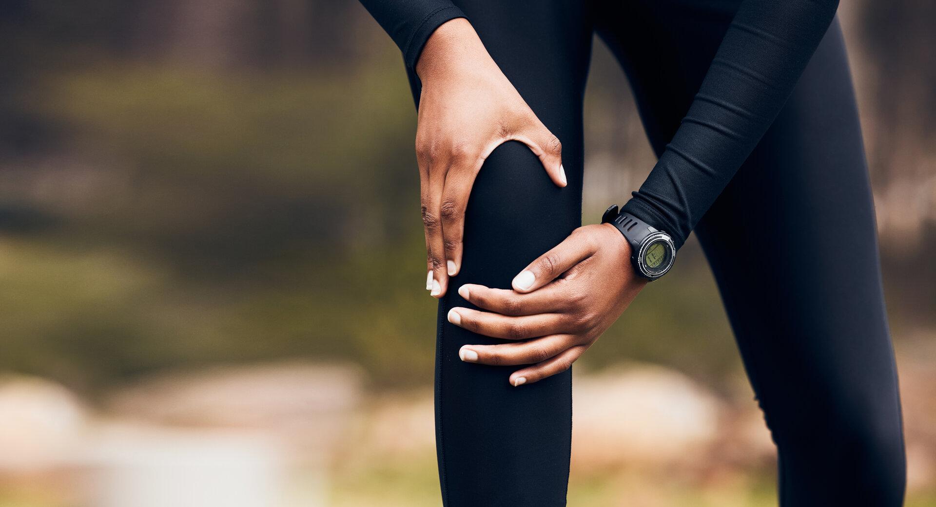 Eine Frau greift sich ans Knie.