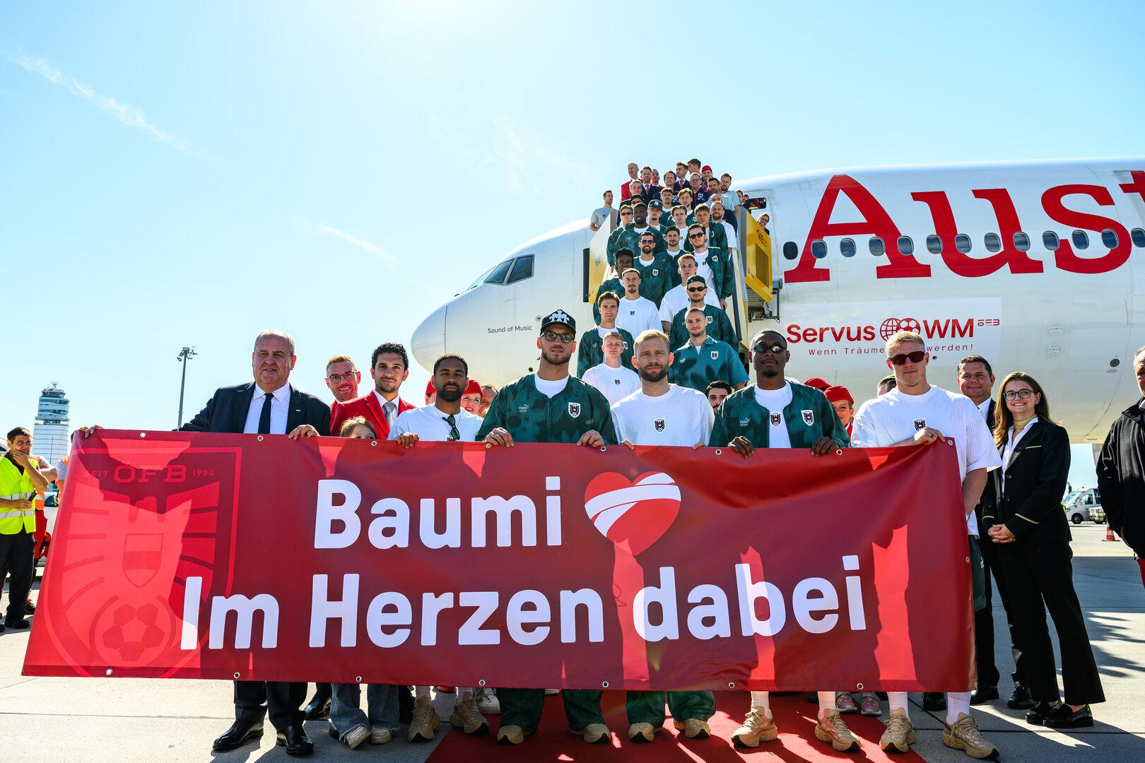 Das ÖFB-Team präsentiert vor dem AUA-Flieger ein Transparent für Baumgartner.