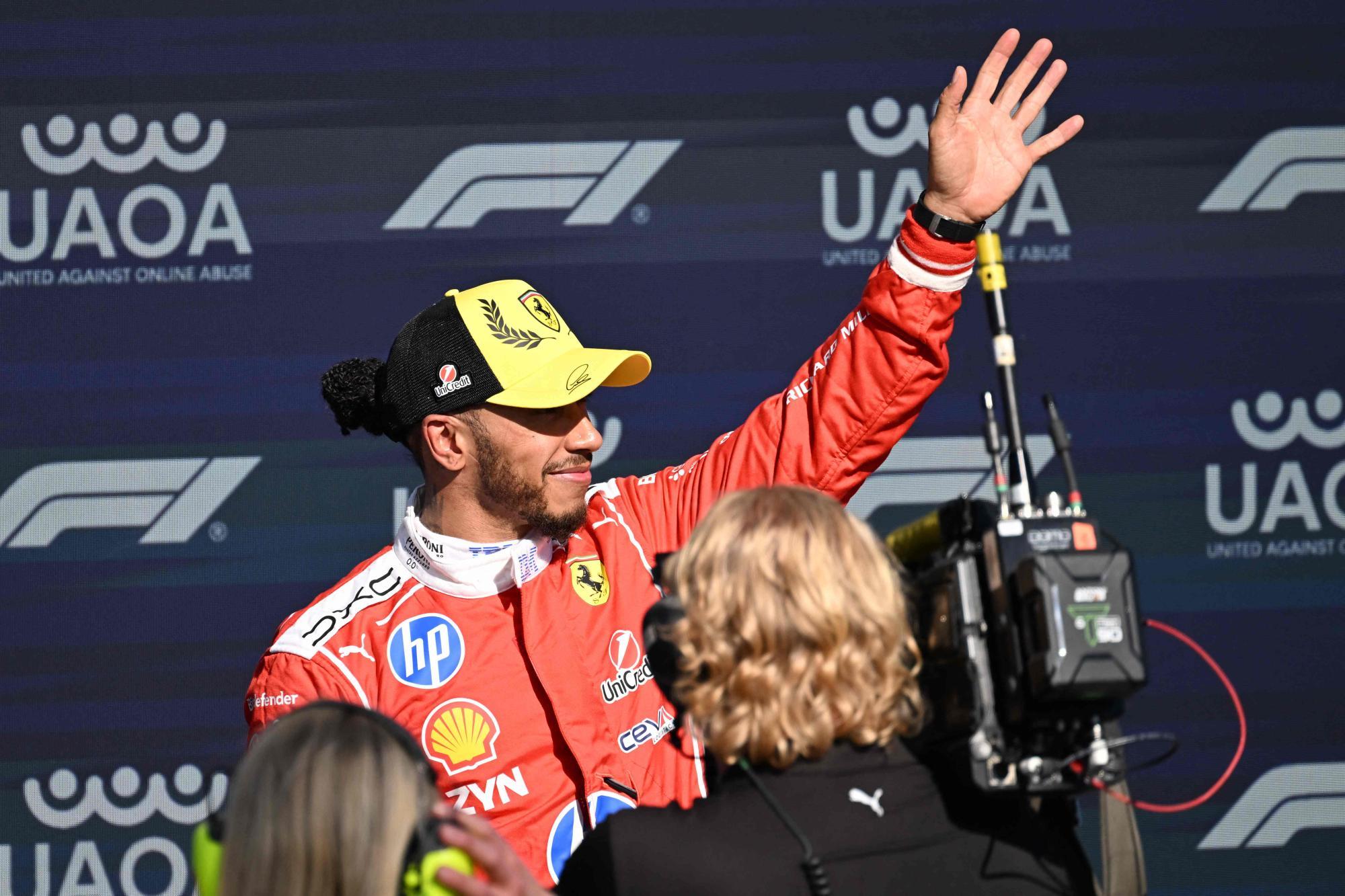 Lewis Hamilton jubelt. Er hat eine schwarz-gelbe Kappe auf. 